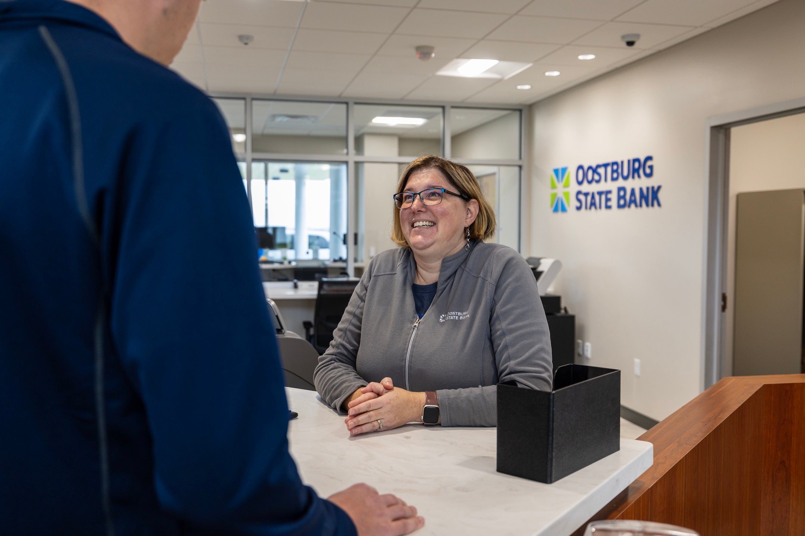 Person interacting with a bank teller at Oostburg State Bank
