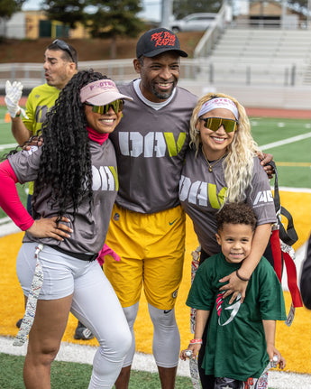 Family posing together on a sports field with 'DIVA' shirts