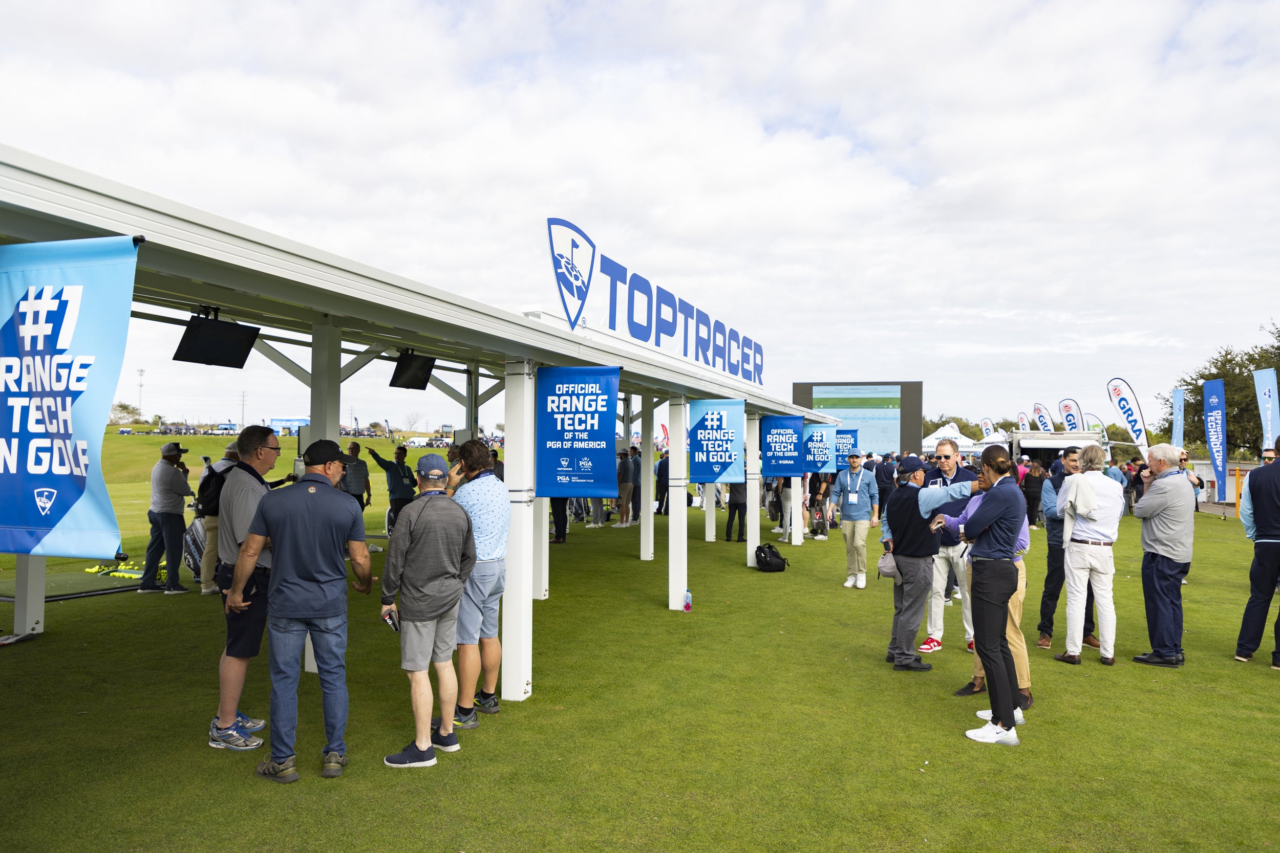 Golf event with Toptracer branding and people on a golf course