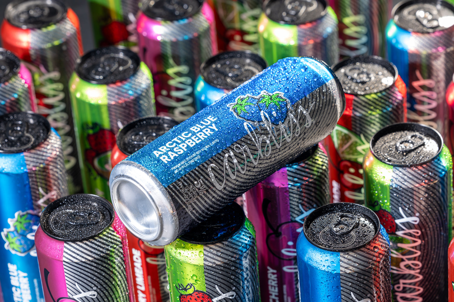 Assorted energy drink cans with a focus on Arctic Blue Raspberry Caffeine can.