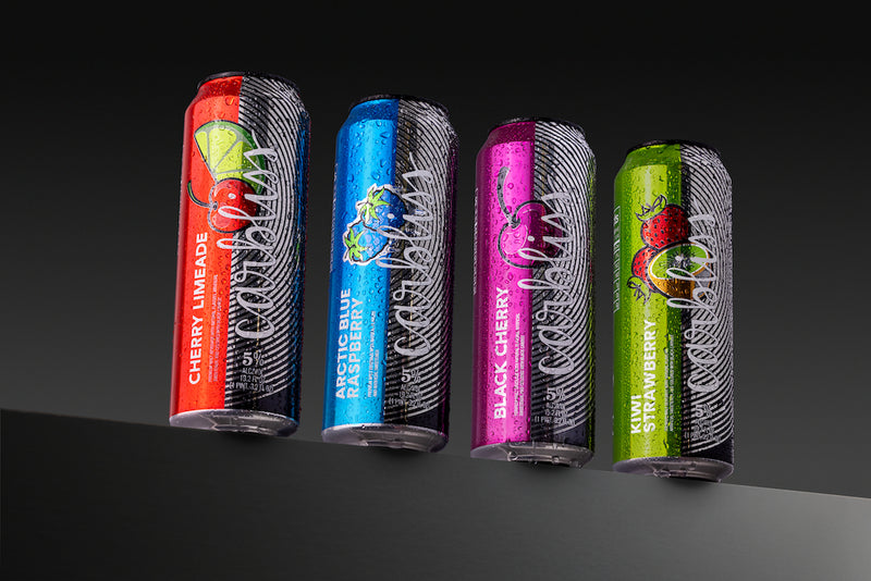 Four colorful cans of a beverage with different flavors on a black and gray gradient background.