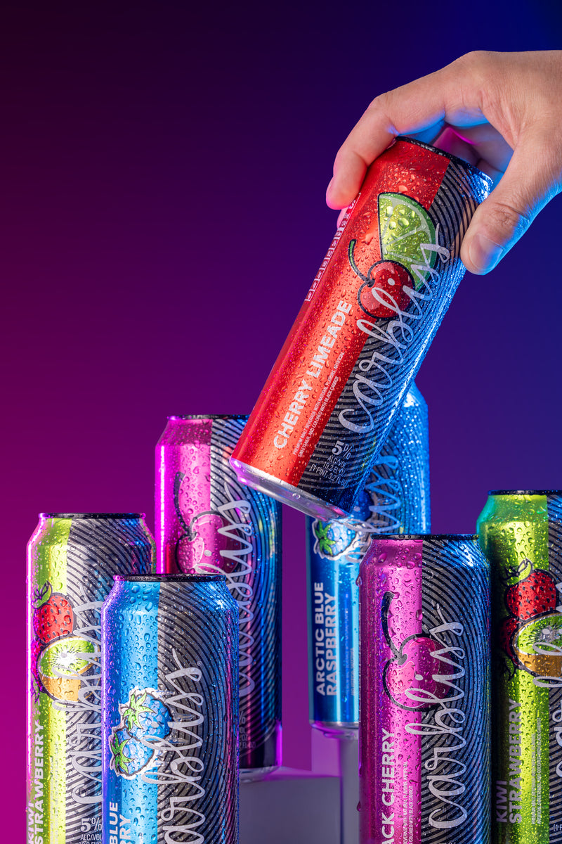 Hand holding a can of Arctic Blue soda with colorful cans in the background on a purple gradient background