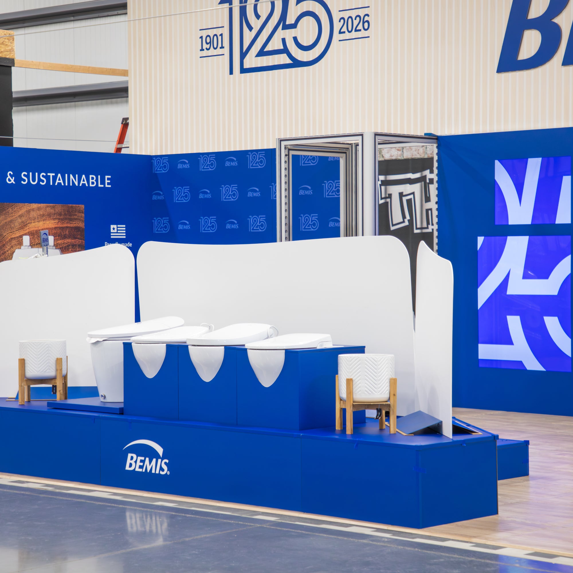 Bemis display with white furniture and blue platform in a showroom setting