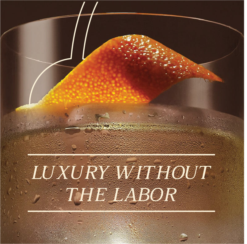 Close-up of a cocktail with a garnish, featuring the text 'Luxury Without the Labor'.