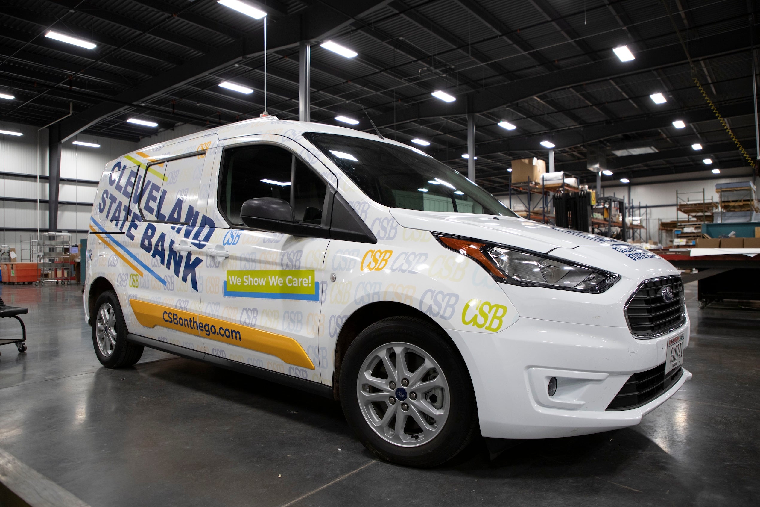 White Cleveland State Bank van with "We Show We Care!" slogan parked inside a warehouse.