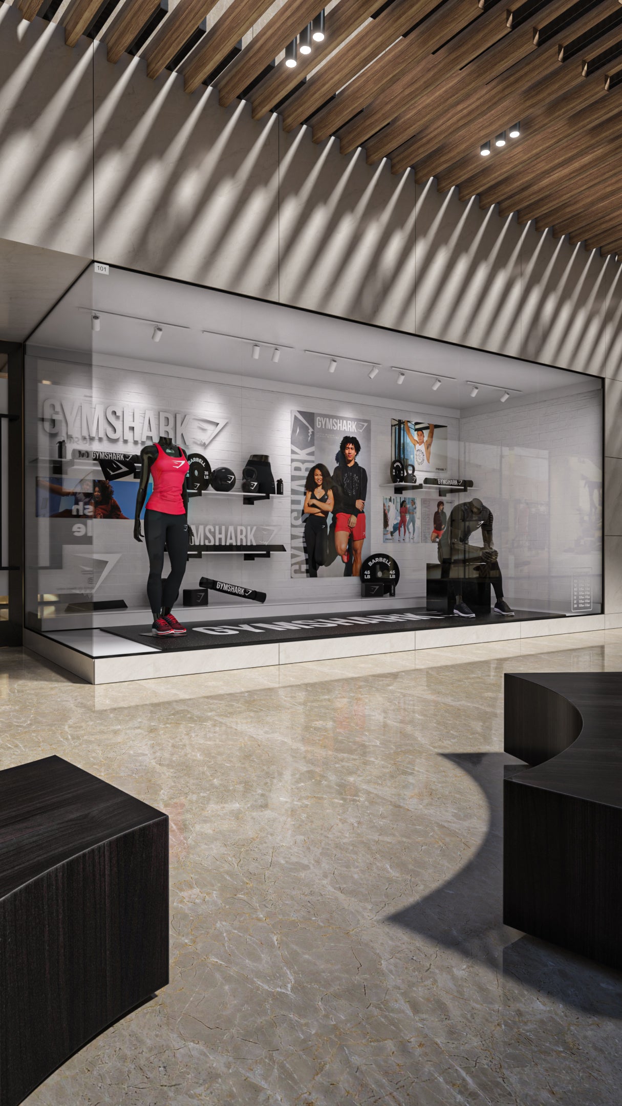 Display case in a store with mannequins and gym equipment, featuring the brand 'Gym Shape'.