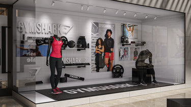 Gymshark store display with mannequins and fitness equipment.