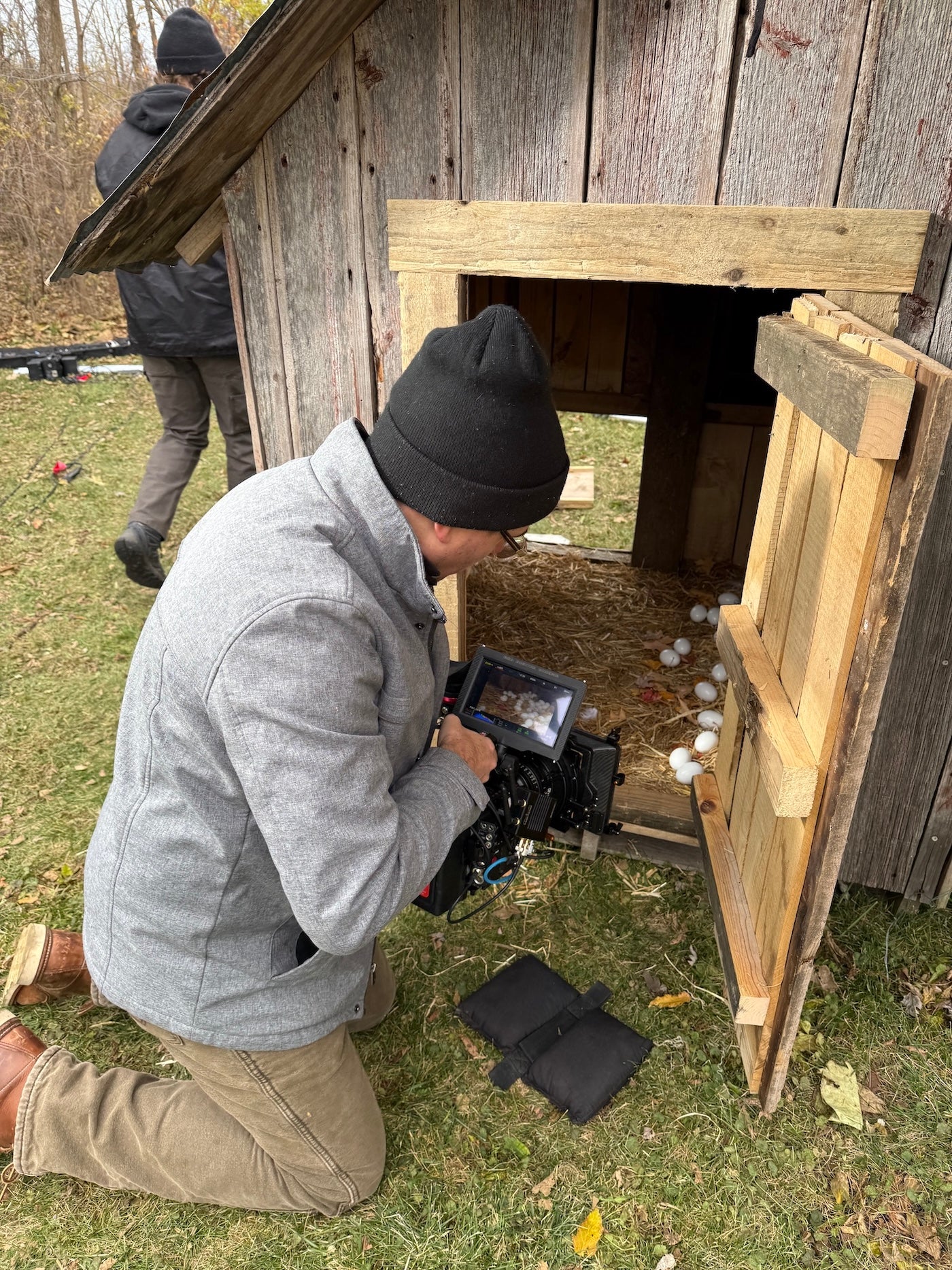 Person filming a rustic wooden structure outdoors