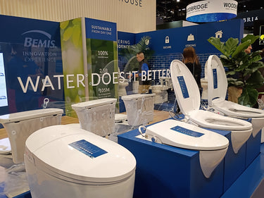 Display of toilets with branding and promotional text at an event.