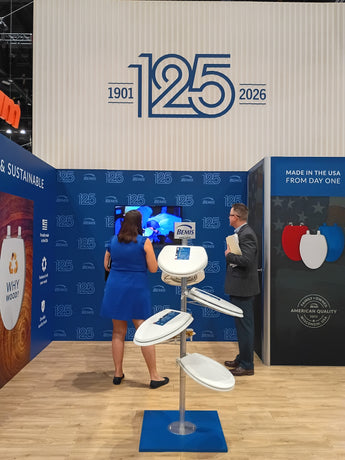Two people interacting with a display at an event celebrating 125 years, with a blue and white theme.